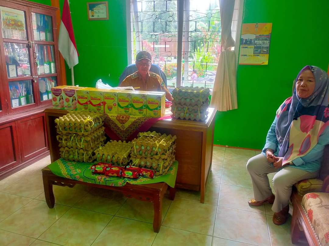 Wali Nagari Koto Berapak didampingi oleh bidan desa Koto Berapak berikan makanan tambahan untuk Bumi