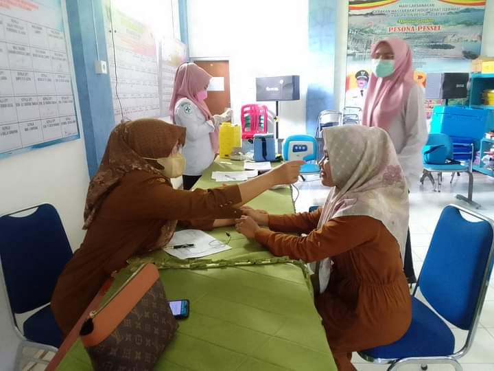 Pelaksanakan kegiatan vaksin covid-19 di aula Puskesmas Lumpo