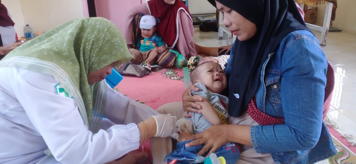 Pemberian Imunisasi di Posyandu PKM BBB